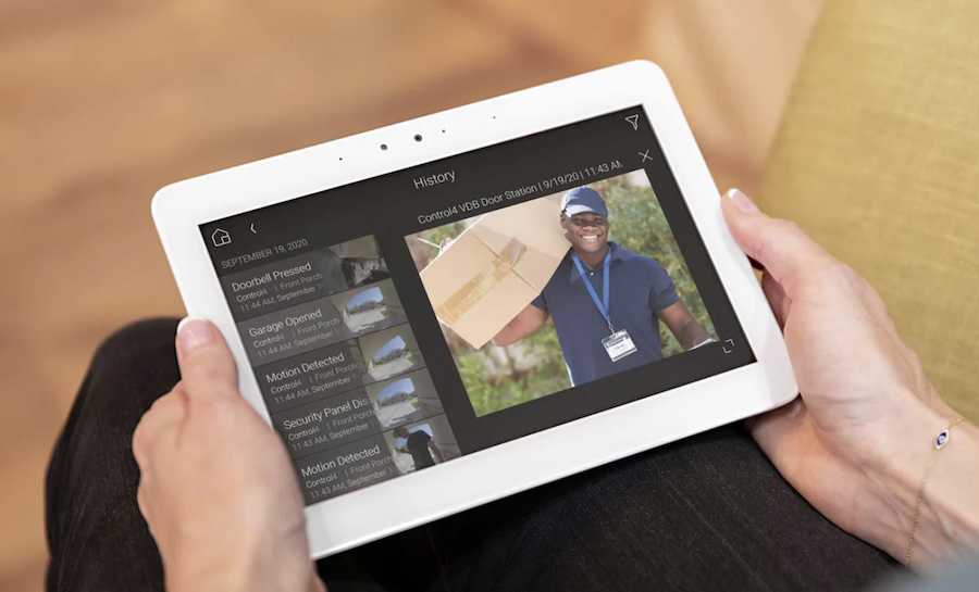 closeup of a Control4 tablet’s security system interface with historical alerts and video feed of a delivery person.